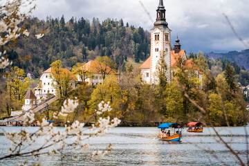 Hermosa postal del Lago de Bled, en Eslovénia, un día de otoño, con embarcaciones navegando en el agua © Javier