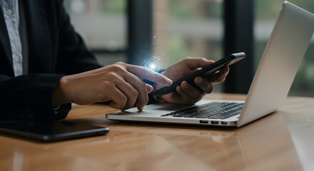 Close-up of person in a suit using a smartphone and laptop with futuristic digital interface overlay