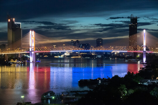 Fototapeta Sunset over the Riverside in Bangkok  skyscraper building of Bangkok’s downtown with skyline buildings and Chao Phraya River, It’s capital city of Thailand