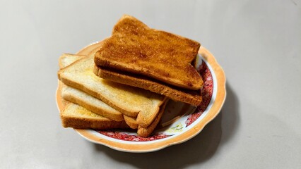 Delicious Crispy Toast on the white and yellow plate isolated on gray background