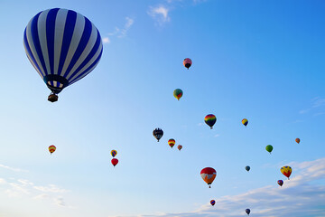 Fototapeta premium Many colorful hot air balloons floating in a bright blue sky