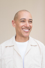Fototapeta premium Bald Latin man face in casual shirt against beige background