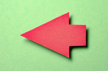 Red cut out blank paper cardboard arrow direction sign with copy space for text on green...