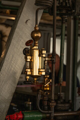 A man is looking at a gold part of a steam engine