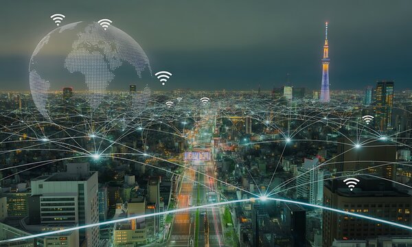 A cityscape at night with digital overlay depicting global internet connectivity. - Powered by Adobe