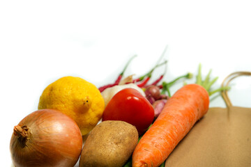 Reusable paper bag with fresh vegetables, fruits, and spices on white background. Eco-friendly, plastic-free, zero-waste lifestyle concept.