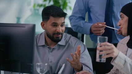 Business team in office happy communicate looking at computer screen analyze work data financial growth marketing strategy together talking three Indian Arabian colleagues discuss job at table smiling - Powered by Adobe