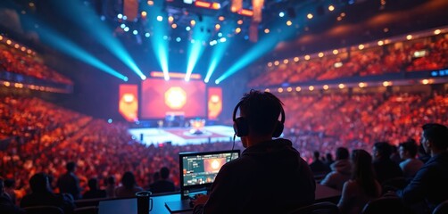 Pro gamer wearing headphones plays online computer game in esports arena filled with spectators. Neon lights illuminate stage, audience. Live streaming setup with monitor shows game interface,