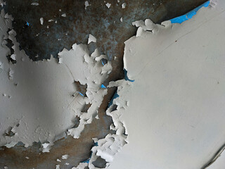 Macro shot of severely peeling paint on a wall, revealing rough layers beneath. Ideal texture for...