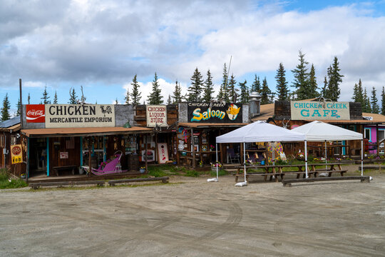 Downtown strip mall with a mercantile store, a saloon and cafe wooden building with colorful facade with lots of signs, Chicken, Alaska