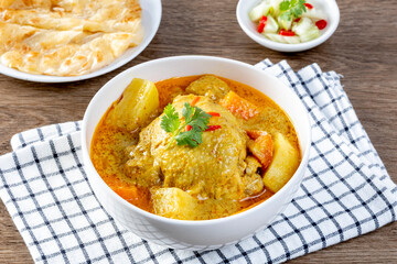 thai yellow chicken curry and roti in the white bowl