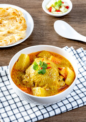 thai yellow chicken curry and roti in the white bowl