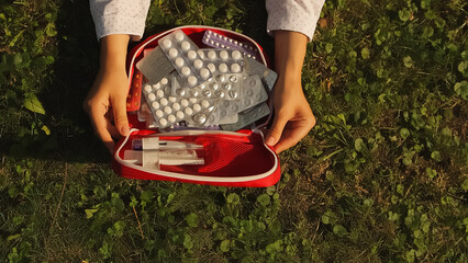 First aid kit. woman lying on grass. High quality photo.