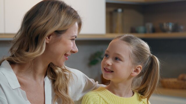 Family happy portrait at home kitchen Caucasian little child daughter look at mother woman smiling caring mom with kid girl looking at each other together toothy smile custody childcare motherhood - Powered by Adobe
