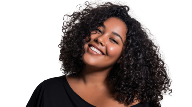 Smiling woman with curly hair, showcasing confidence and joy against a neutral backdrop.