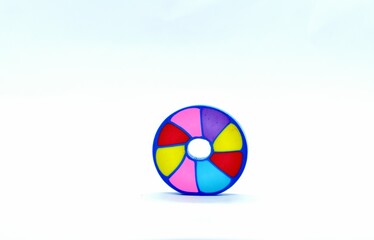 A colorful round bead with blue outer rim and multicolored segments, isolated on a white background, ideal for jewelry making and craft projects.