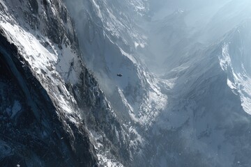 Aerial view of snow-capped mountains with a small dark object in the middle distance