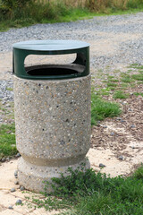 Obraz premium Concrete trash can with green lid in park