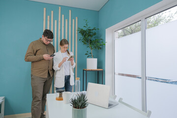 millennial man and woman working in small office discussing documents