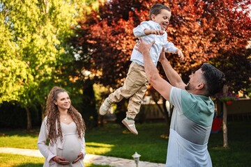 Fototapeta premium Joyful family moment under blooming trees in springtime