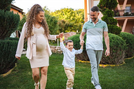 Joyful family stroll in a lush garden during golden hour