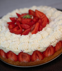 This fraisier cake showcases layers of fresh strawberries and chantilly cream on a golden sponge base, presented beautifully for dessert enthusiasts during a special gathering.