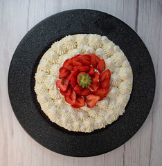 This fraisier cake showcases layers of fresh strawberries and chantilly cream on a golden sponge base, presented beautifully for dessert enthusiasts during a special gathering.