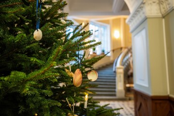 Close-up of decorated Christmas tree with seashell ornaments in elegant building interior