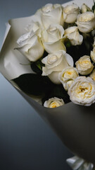 Beautiful white roses in a flower shop. Florist assembles a bouquet to order