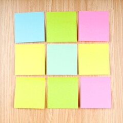 Fototapeta premium Colorful Sticky Notes Arranged on Wooden Surface for Message Reminders and Ideas
