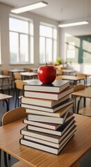 A red apple sits on a tall stack of books on a desk in an empty sunlit classroom. Back to school and education concept.