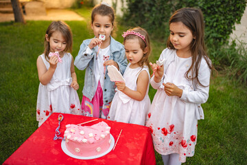 Four girls enjoy sweet treats at a festive outdoor party