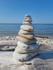 Fototapeta premium Zen Stone Stack on Driftwood at the Beach