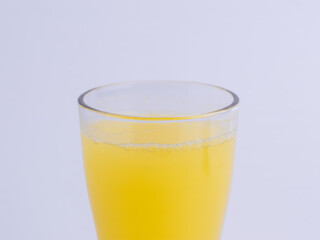 A close up of a glass of fresh orange juice with bubbles on a white background. Concepts for healthy drink, citrus, vitamin C, breakfast, beverage, refreshment, fresh, isolated.
