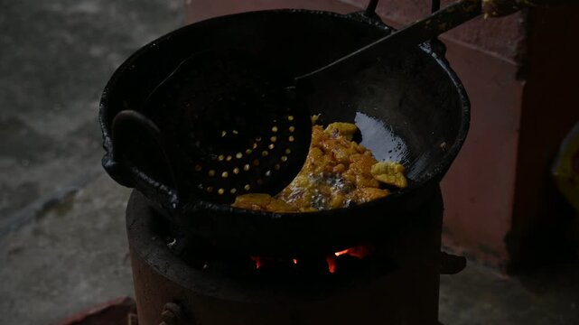 Onion pakora frying in iron pen. This is a popular street food in Indian subcontinent. Onion which are coated in seasoned&nbsp;spicy gram flour&nbsp;batter and deep fried. It originated in India.