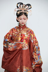 Obraz premium A cute girl wearing a Ming Dynasty phoenix coronet and embroidered robe against a white background.