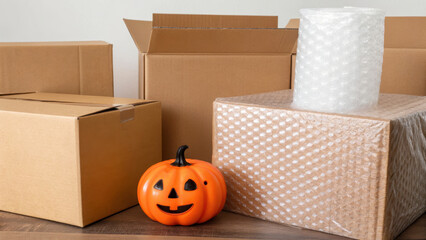 Halloween packaging includes cardboard boxes and bubble wrap, creating festive atmosphere. orange pumpkin adds playful touch to scene