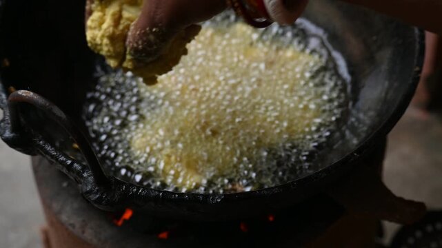 Onion pakora frying in iron pen. This is a popular street food in Indian subcontinent. Onion which are coated in seasoned&nbsp;spicy gram flour&nbsp;batter and deep fried. It originated in India.