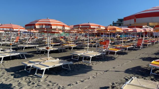 Sestri Levante, Italy - August 9, 2025. Beach umbrellas and sun loungers by sea. Summer, vacation in Liguria, Italy. Background for text.