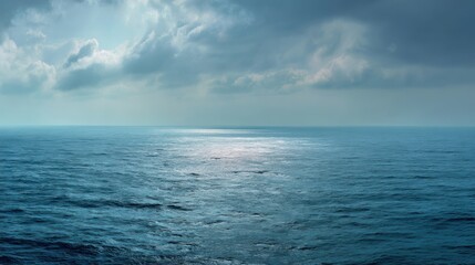 Obraz premium Calm ocean surface reflecting sky with blue hues and soft clouds, creating a serene and peaceful atmosphere.