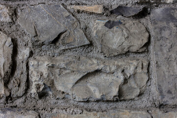 Close-up detail of weathered stone wall with aged mortar and natural weathering patterns. Traditional Irish building construction showing texture and patina.