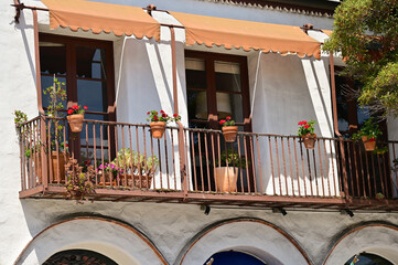 Italian balconies with canvas awnings, and wrought iron railings