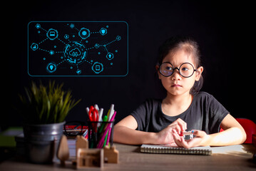 A focused young girl wearing round glasses writes in her notebook, with a futuristic blue...