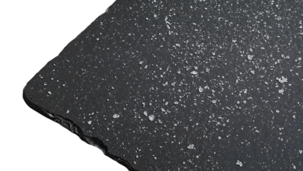 Coarse salt crystals scattered on black slate stone with rough textured edges, culinary ingredient background