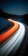Traffic flows along a winding road illuminated by vehicle lights at dusk in a mountainous area