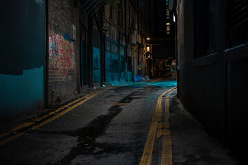 Dark Dublin alley with graffiti street art and atmospheric blue lighting. Urban underground scene with wet pavement and industrial architecture.