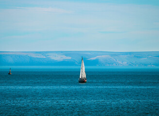 A sailing boat out at sea, taken from Sandy Bay Beach Porthcawl, South Wales, UK
