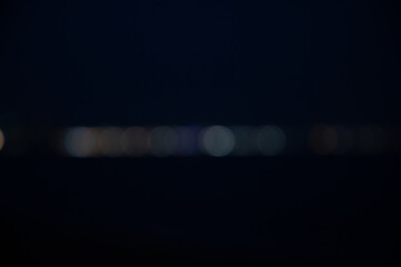 Bokeh on night background. Blurred glowing lights on horizon