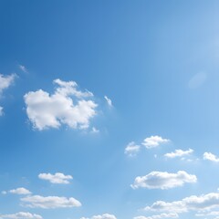 Expansive blue sky with soft white clouds basking in the bright sunlight. A serene and peaceful atmospheric background.