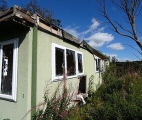 the corner of broken window on a pale green mobile home
